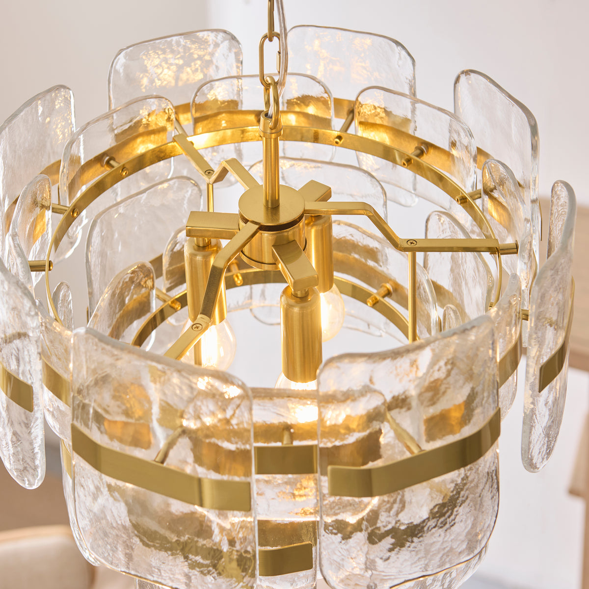 Underside of the Ancara pendant showing its brass frame and three lit filament bulbs