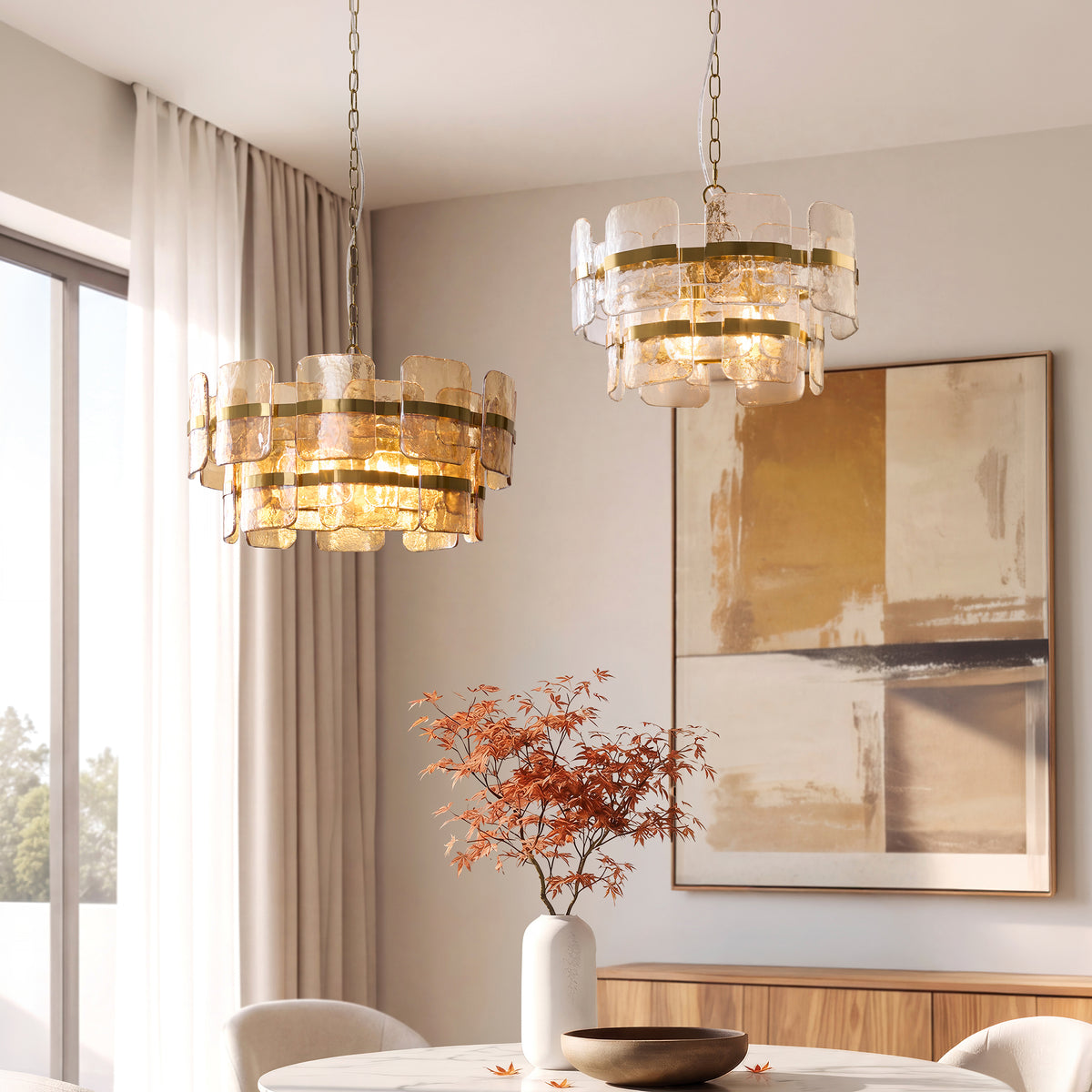 Pair of Ancara brass and glass pendants lit above a marble dining table in a modern room