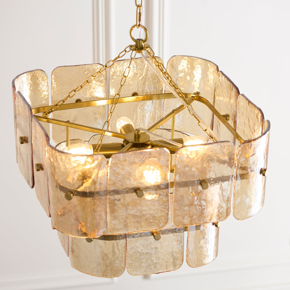 Angled view of the Venice chandelier's brass frame and amber-tinted handmade glass panels