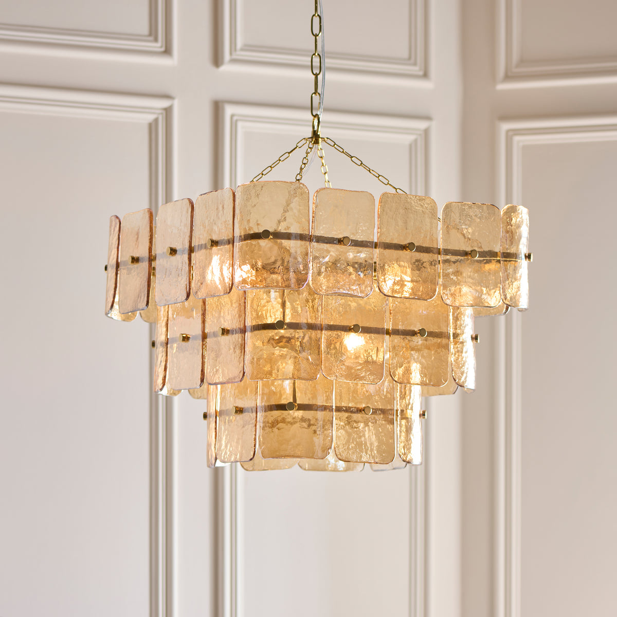 Venice champagne glass pendant glowing warmly against pale panelled walls