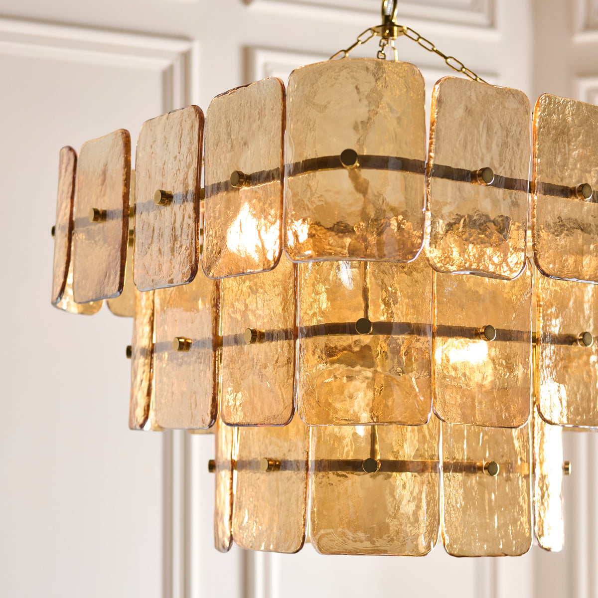 Close-up of the Venice pendant's layered champagne glass panels and slender brass bars