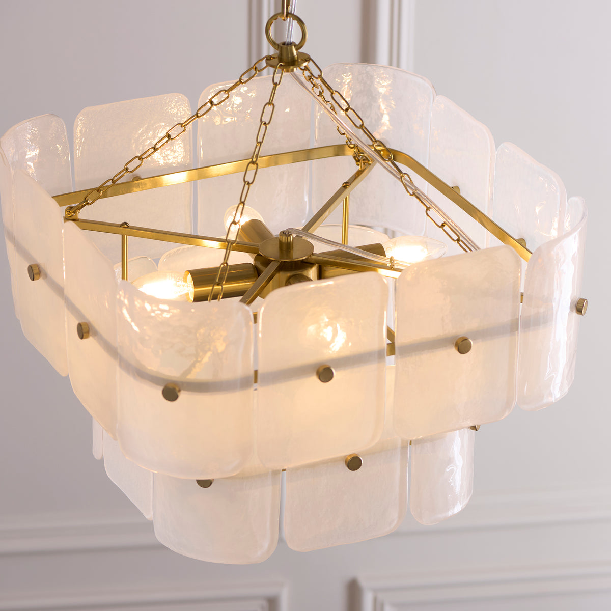Underside of the Venice pendant revealing the brass central stem, lit lamps and white glass panels
