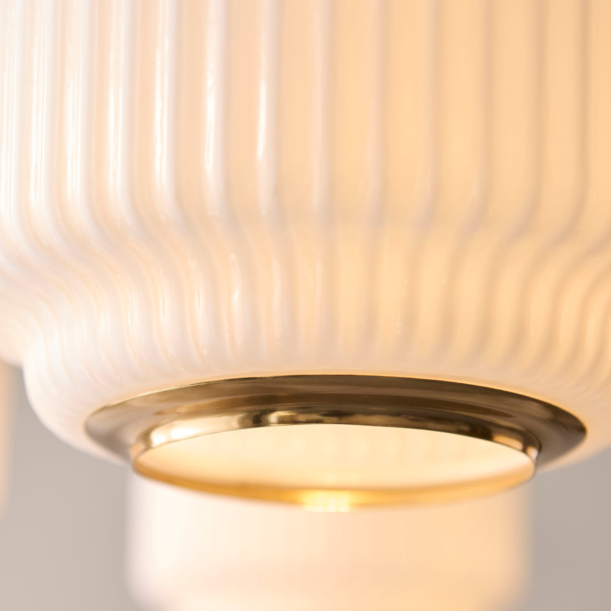 Close-up of one Evora ribbed opal glass shade with its polished brass base ring
