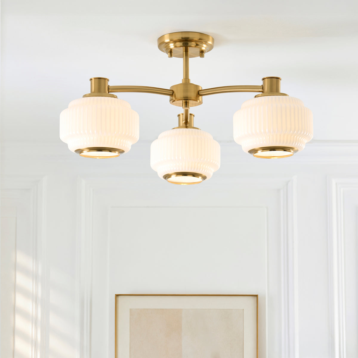 Evora semi flush ceiling light lit in a panelled hallway above framed art, three opal shades