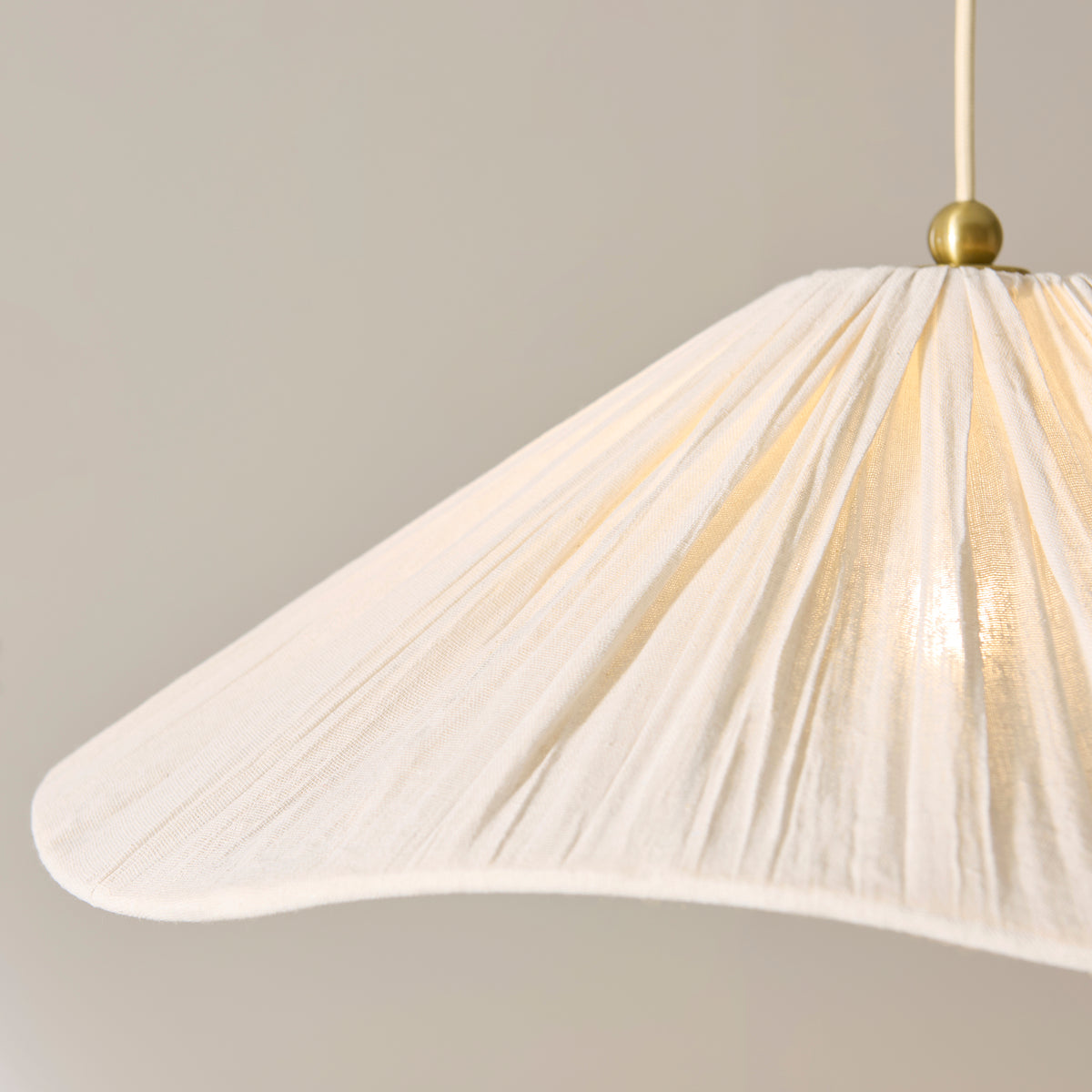 Close-up of the Isabella Grand pendant's wavy pleated ivory fabric shade edge