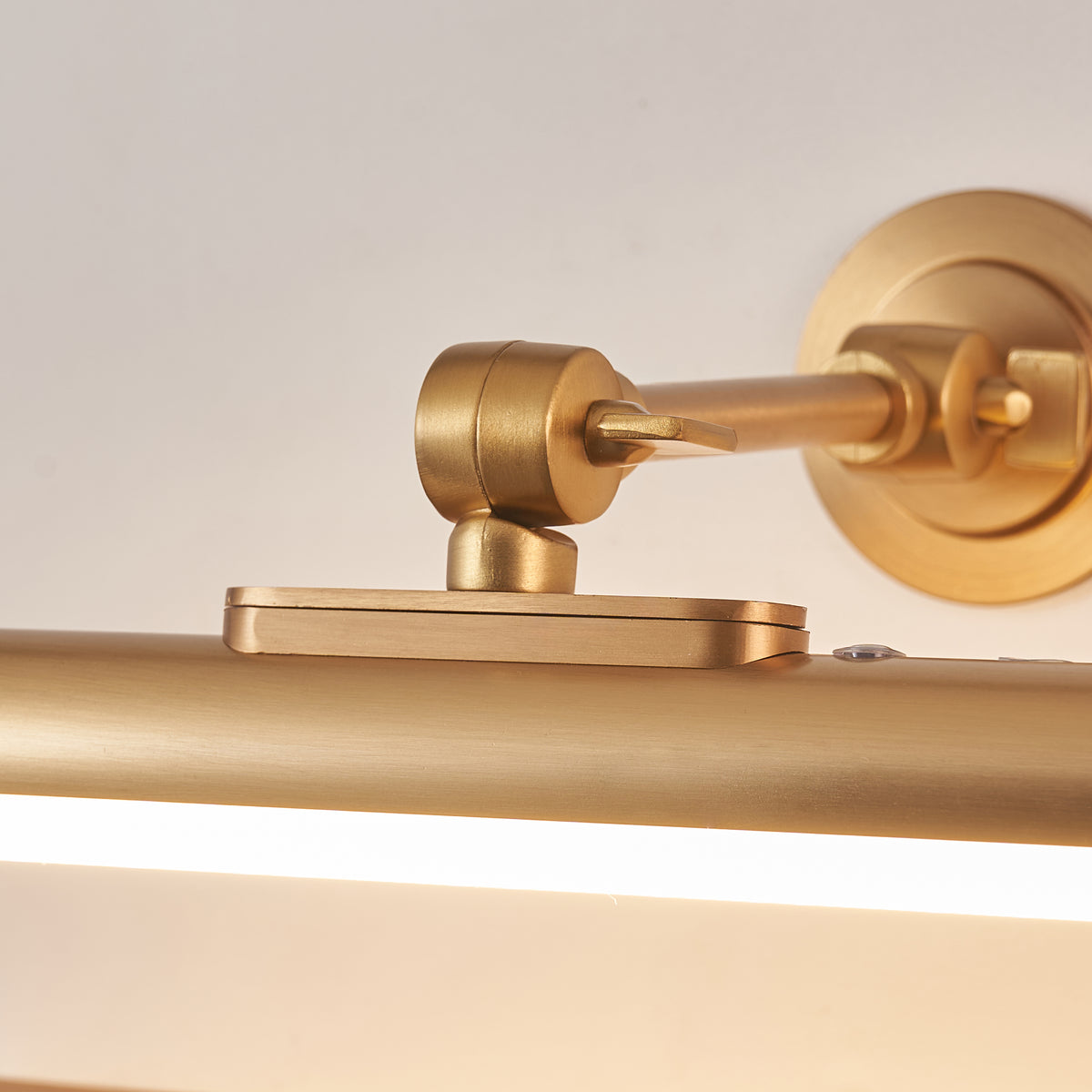 Close-up of the Kas picture light's adjustable brass swivel joint and round wall plate