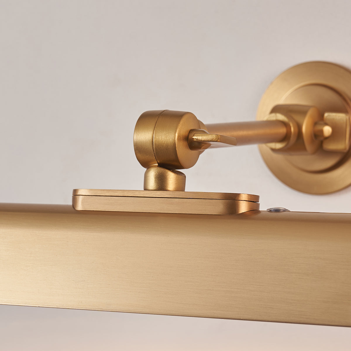 Close-up of the Dalyan light's brass arm, tilt joint and circular wall plate