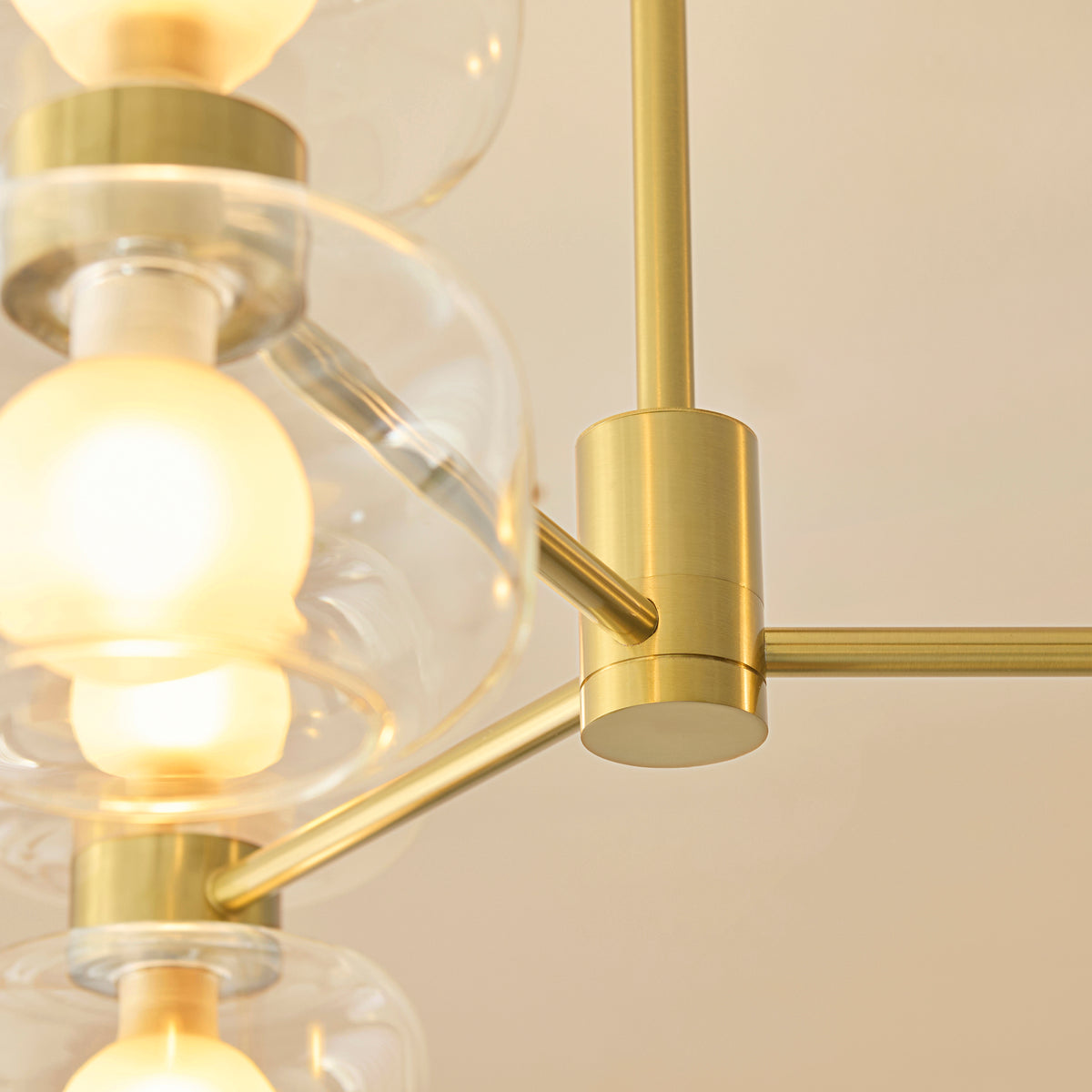 Close-up of the Rossano ceiling light's brushed brass central hub and radiating arms
