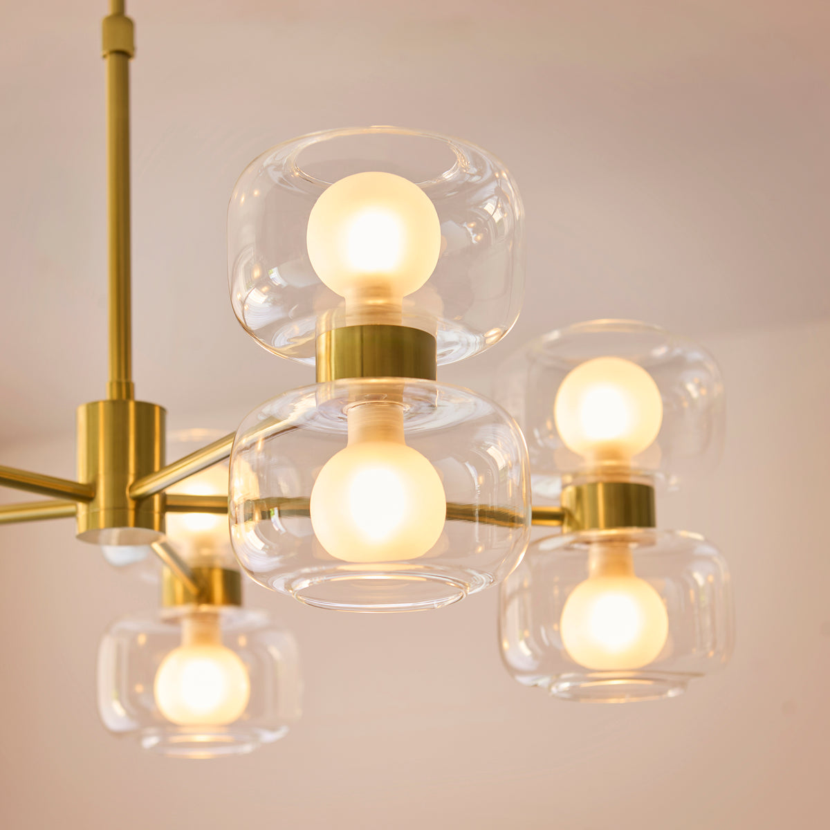 Underside view of the Rossano chandelier showing frosted globes lit inside clear glass shades