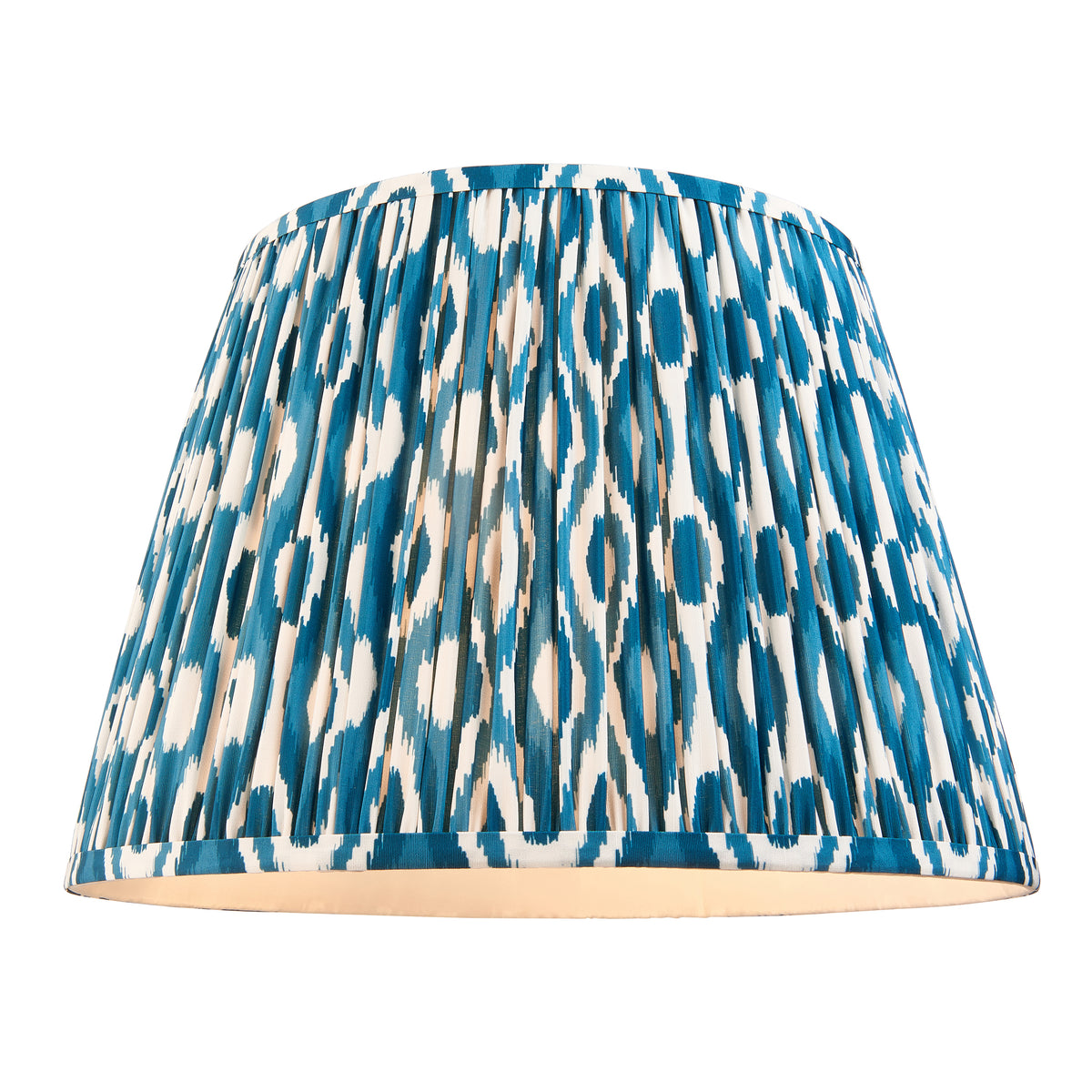 Pleated tapered lampshade in blue and cream ikat fabric, lit from within