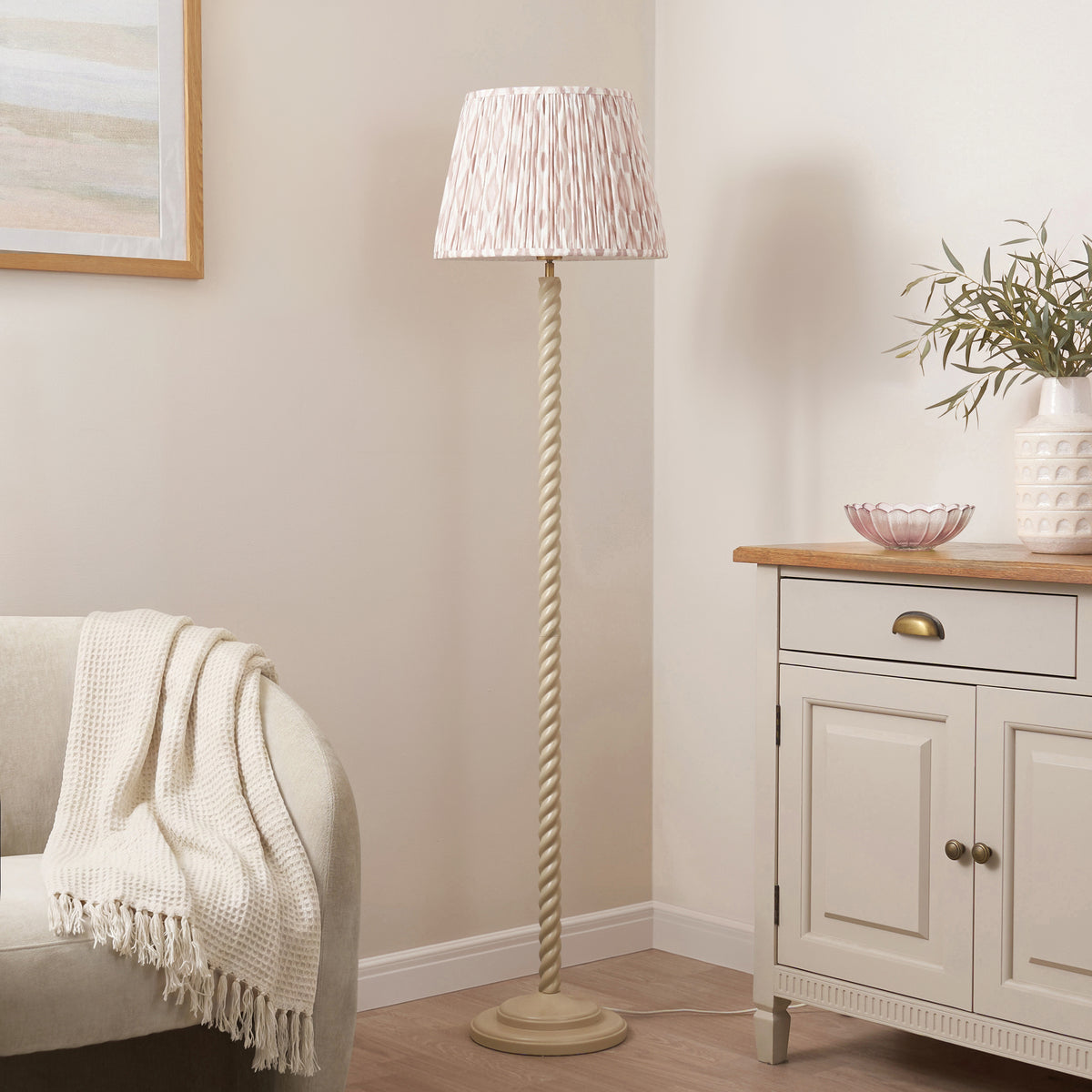 Neutral ikat pleated shade on a twisted almond white floor lamp in a softly furnished living room