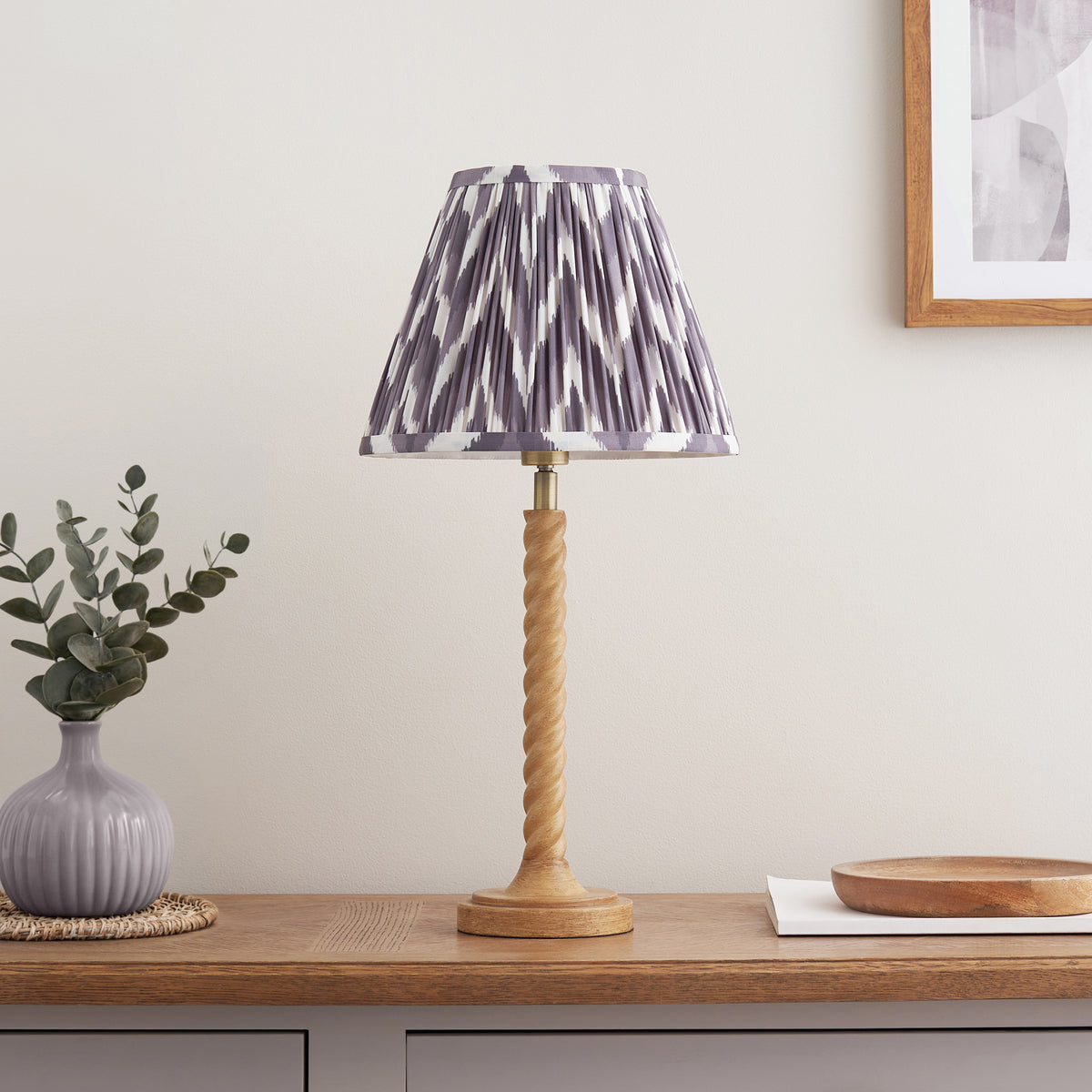 Grey zigzag pleated shade on an oak effect twisted table lamp styled on an oak console with a wooden bowl