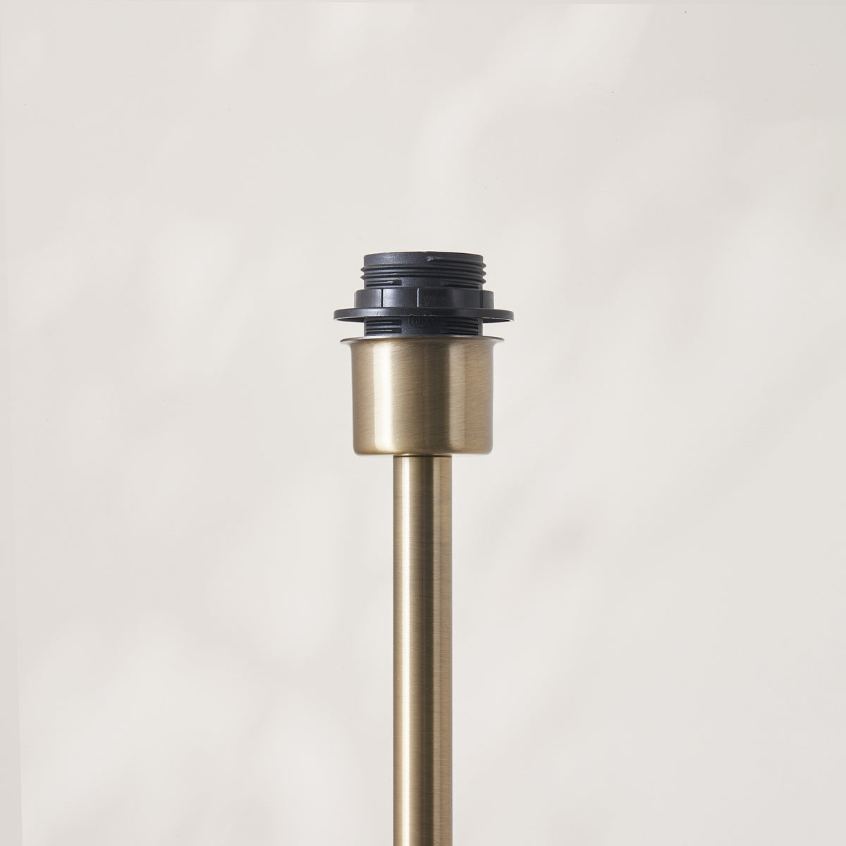 Detail of the antique brass lamp holder at the top of the Arlo floor lamp stem