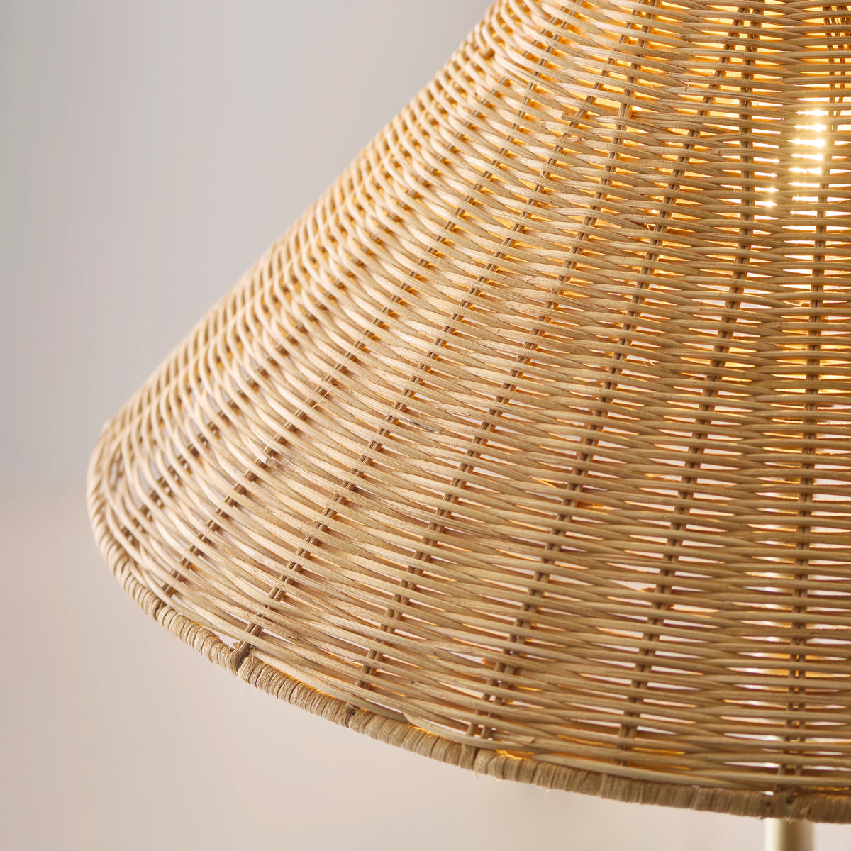Detail of the natural rattan weave of the Arlo shade with warm light glowing through