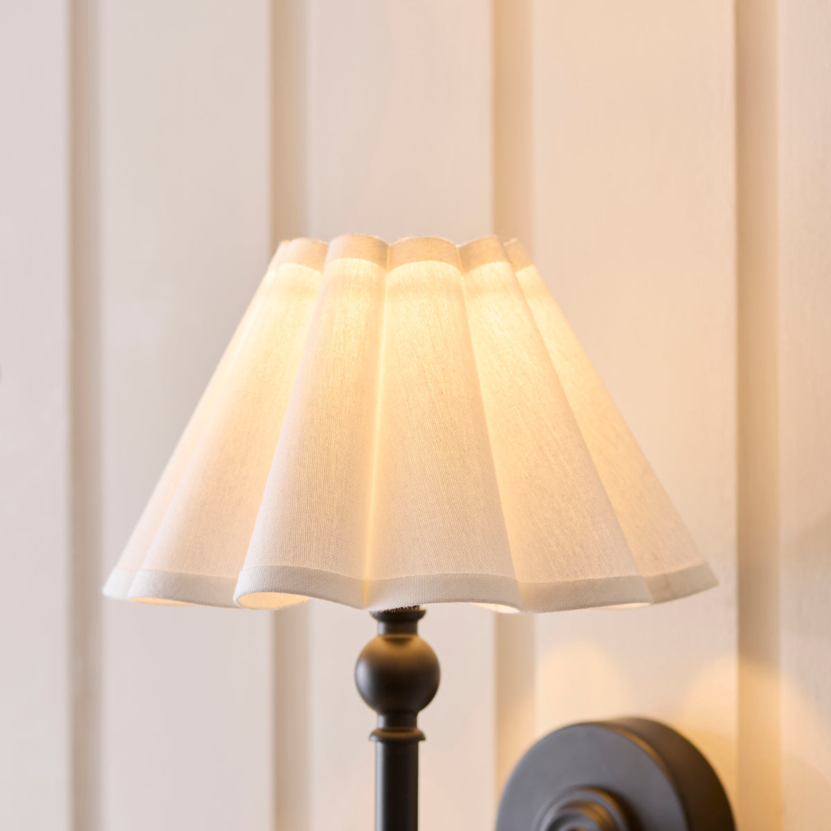Close-up of the Sylvie light's scalloped white linen shade above its black ball detail
