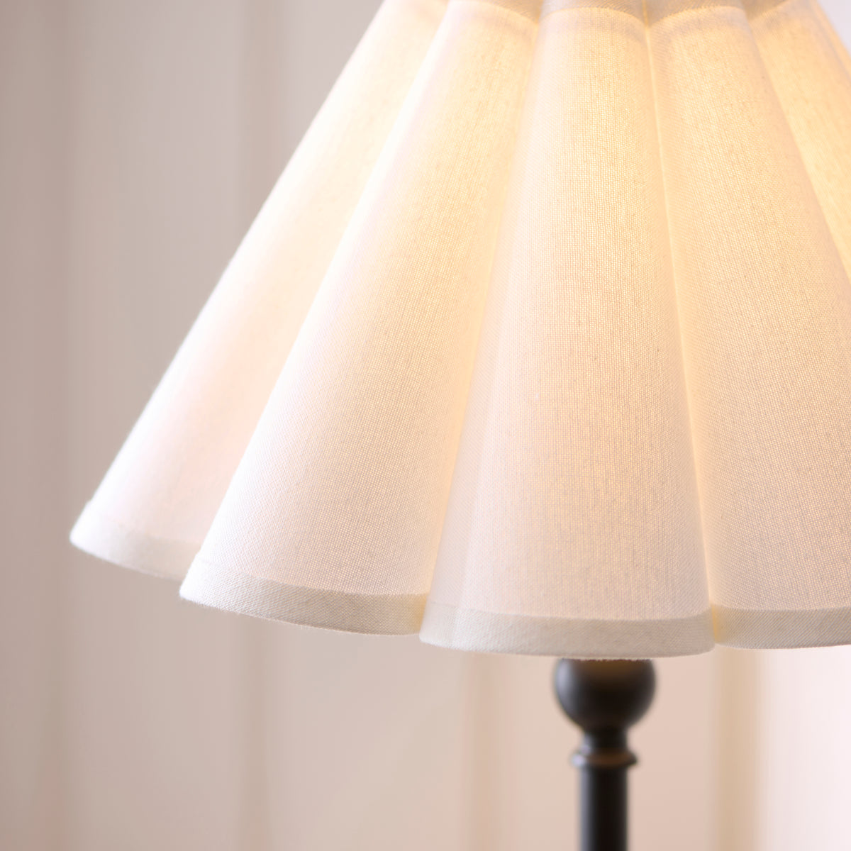 Detail of the pleated white linen shade on the Sylvie black table lamp