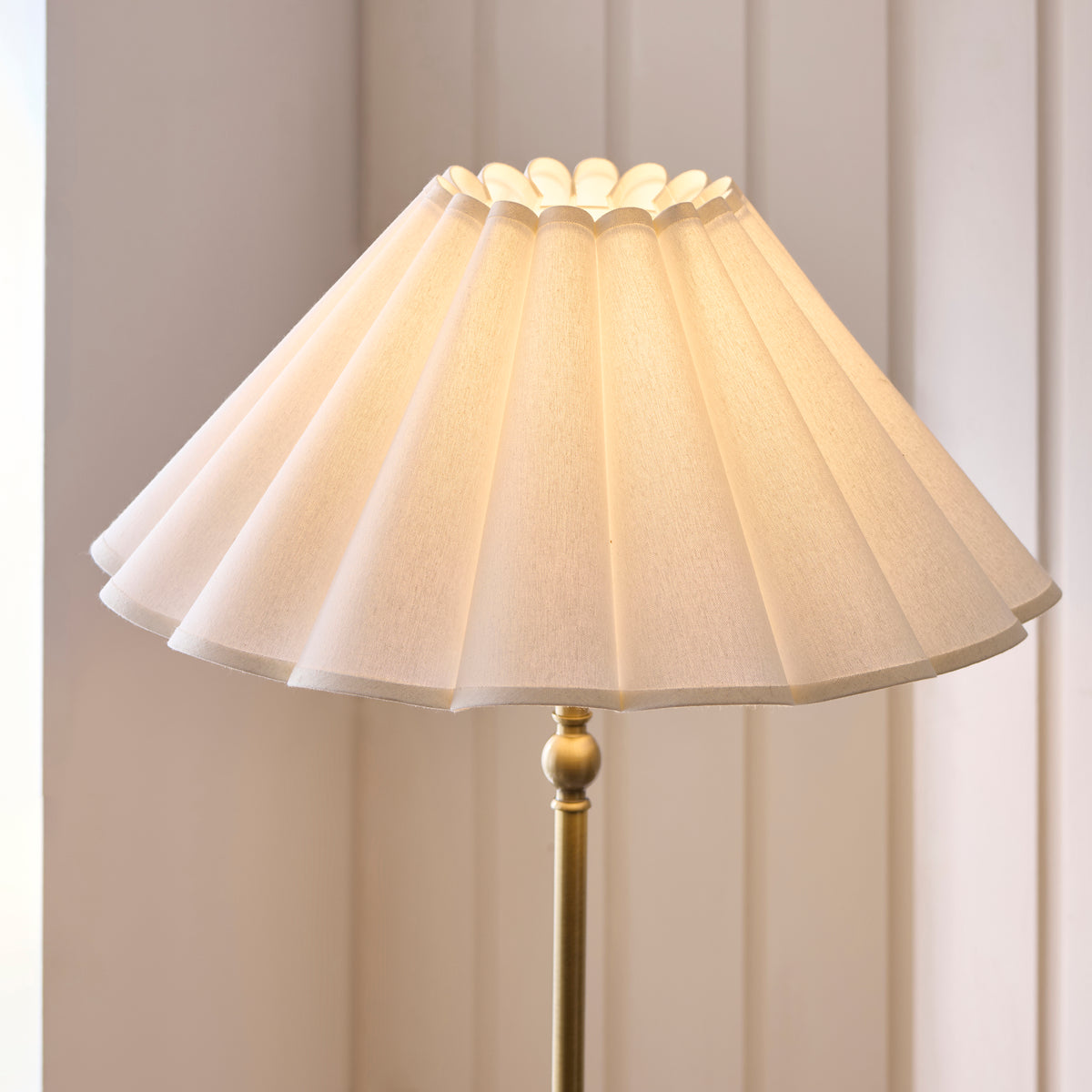 Close-up of the Sylvie floor lamp's pleated white shade with scalloped top edge
