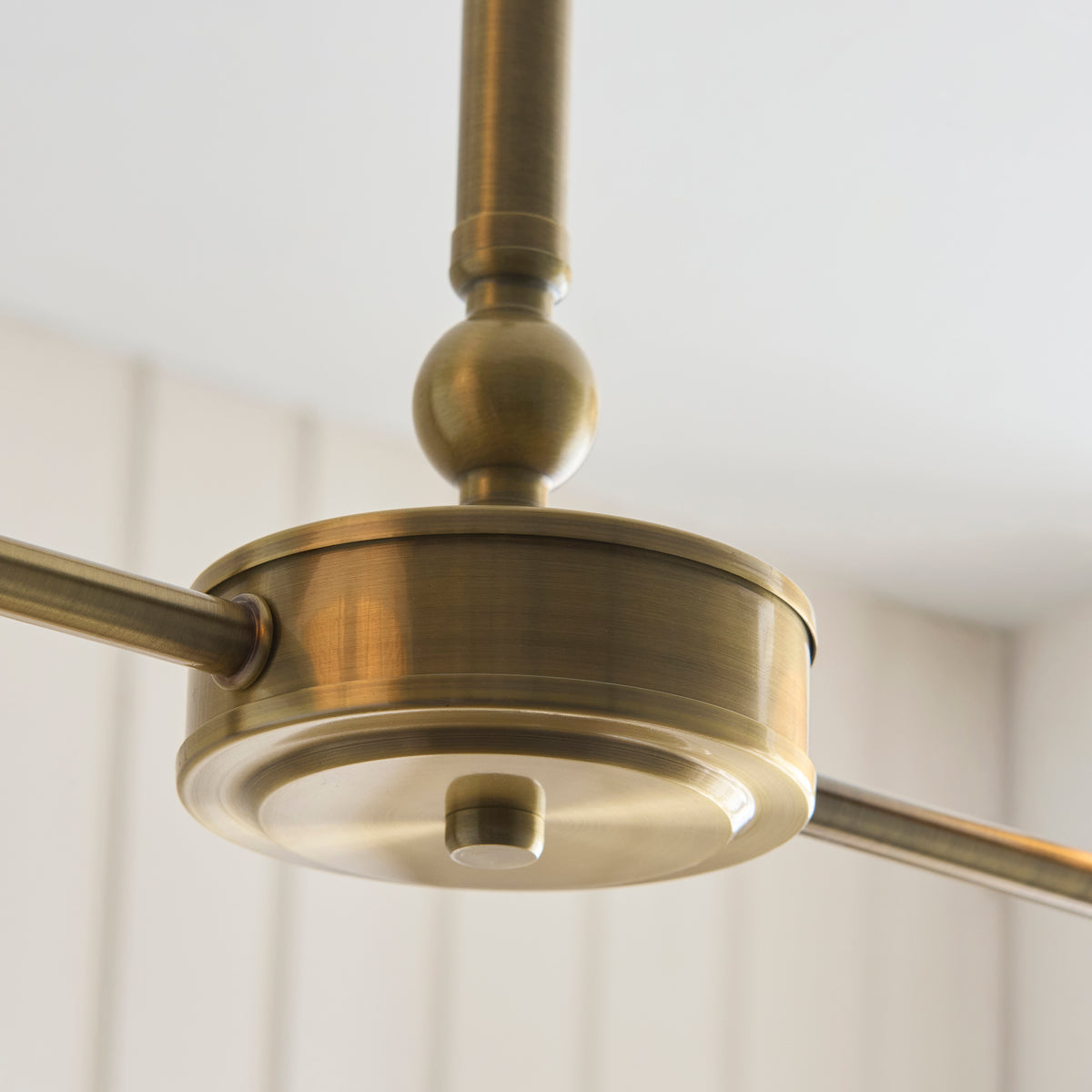 Underside view of the Sylvie linear pendant's brass central hub and arms