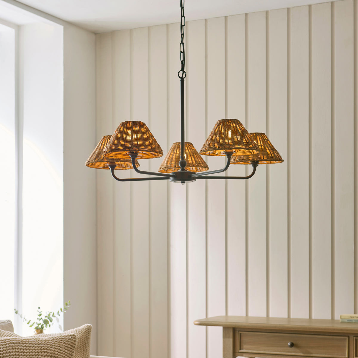 Lit Jericho black five-arm rattan pendant hanging in a panelled living room