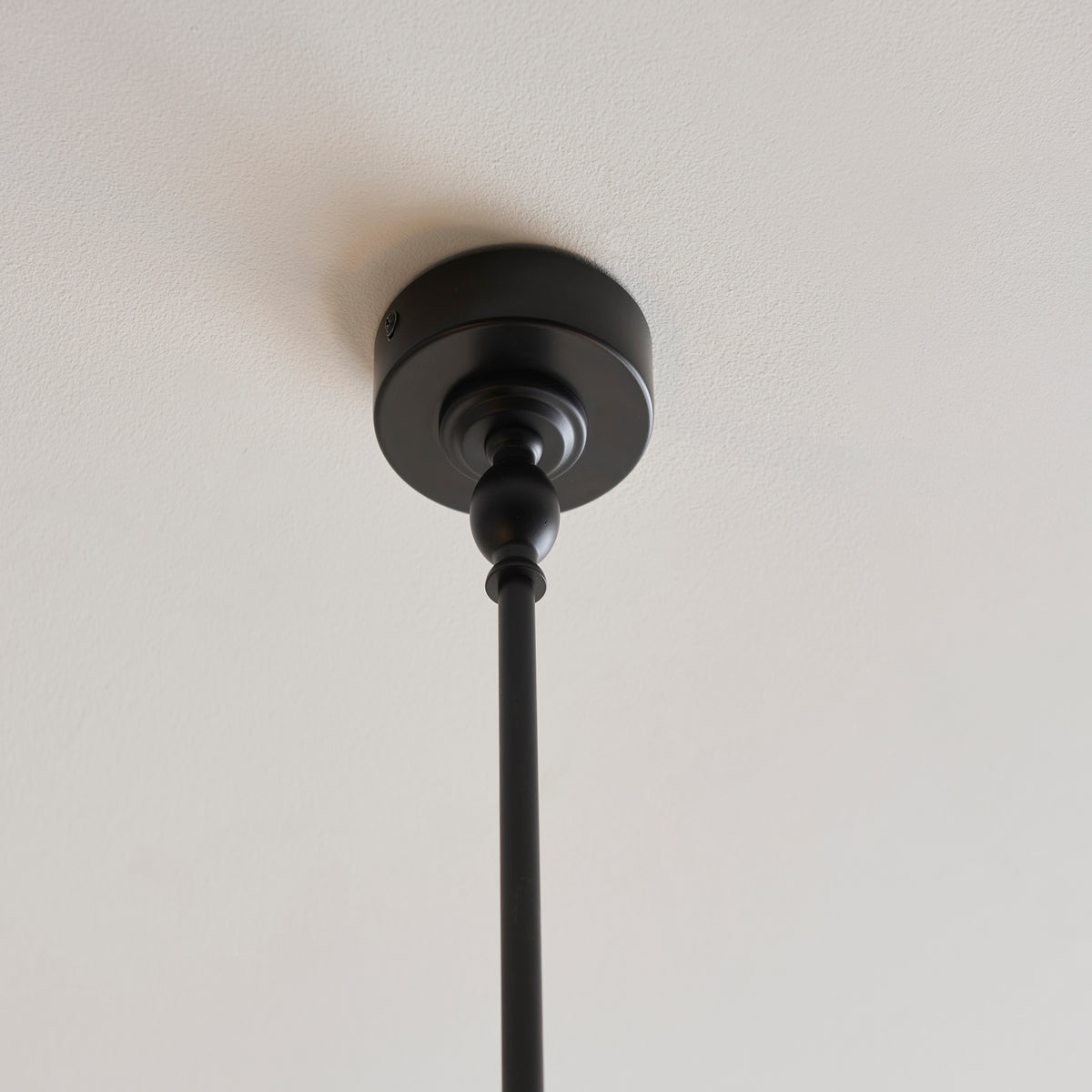 Matt black ceiling rose and drop rod of the Jericho linear pendant