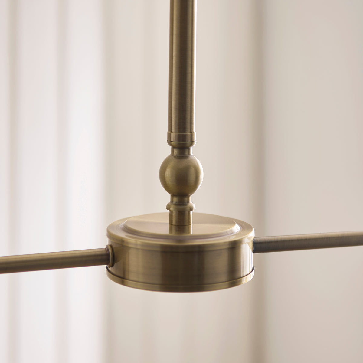 Antique brass central housing and ball detail of the Jericho linear pendant