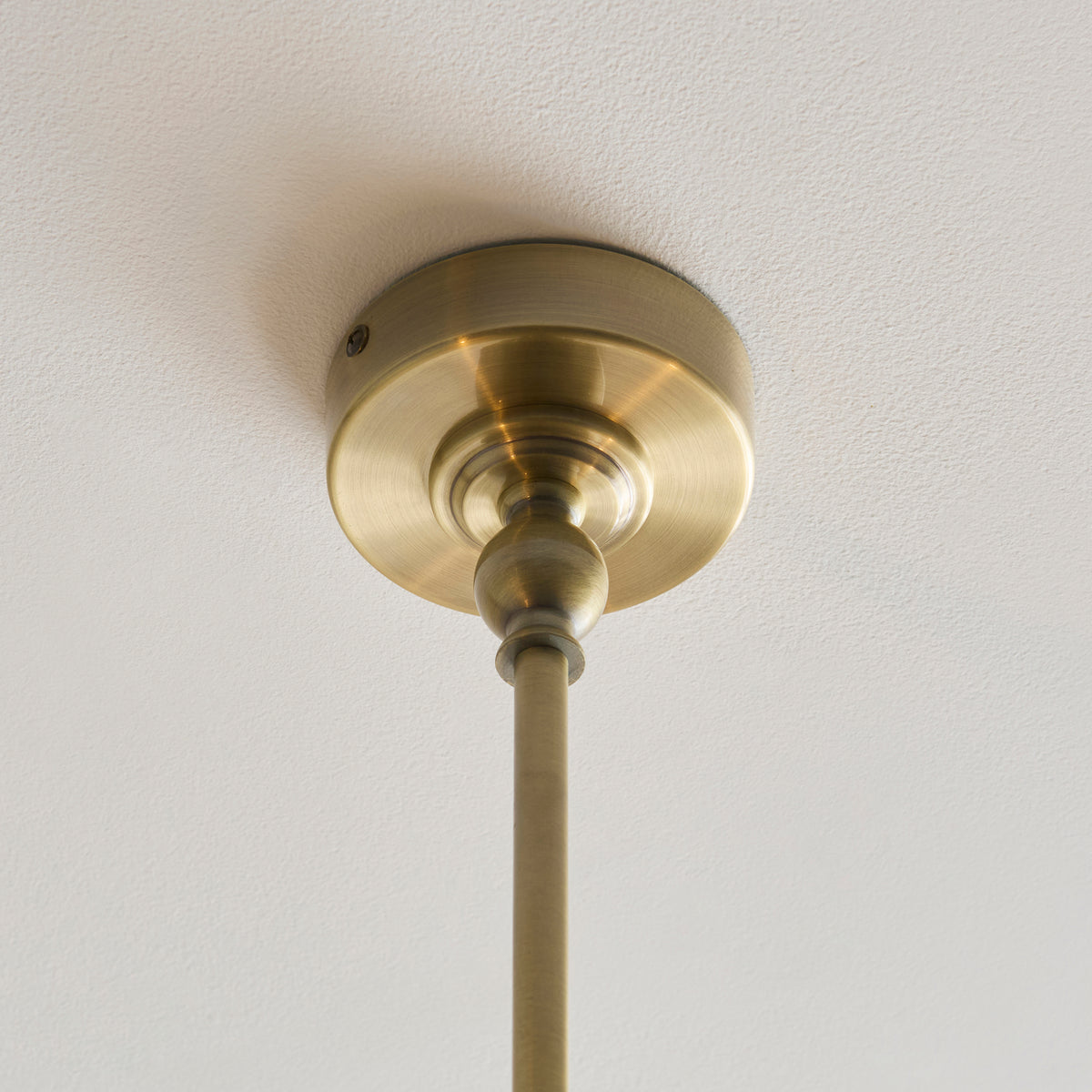 Antique brass ceiling rose and drop rod of the Jericho linear pendant