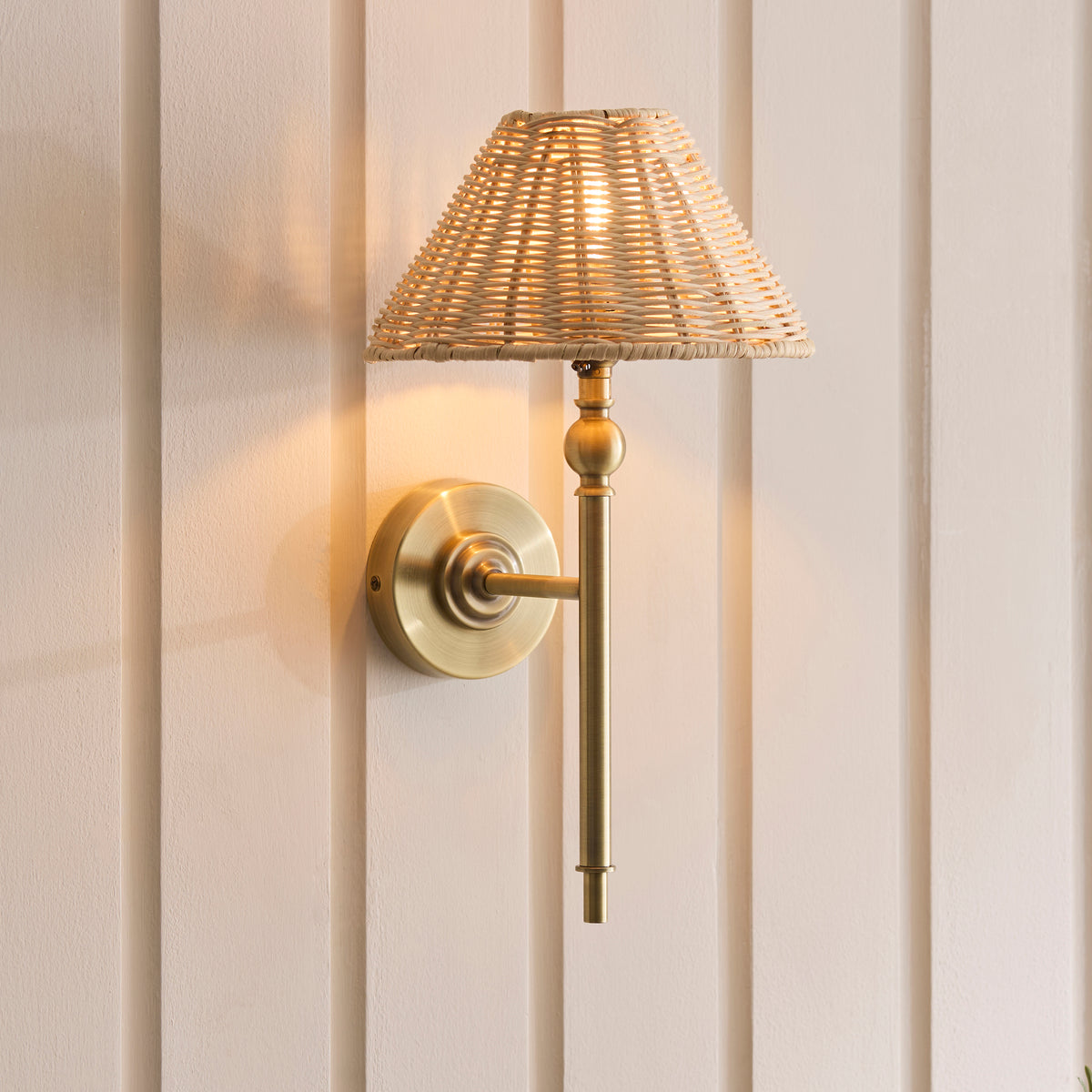 Jericho antique brass wall light lit against tongue-and-groove panelling