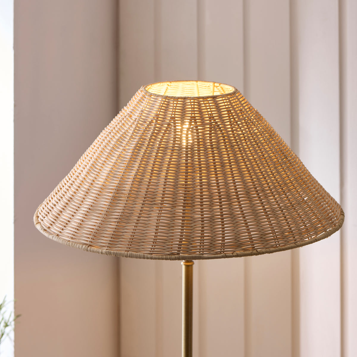 Glowing natural rattan coolie shade of the Jericho antique brass floor lamp