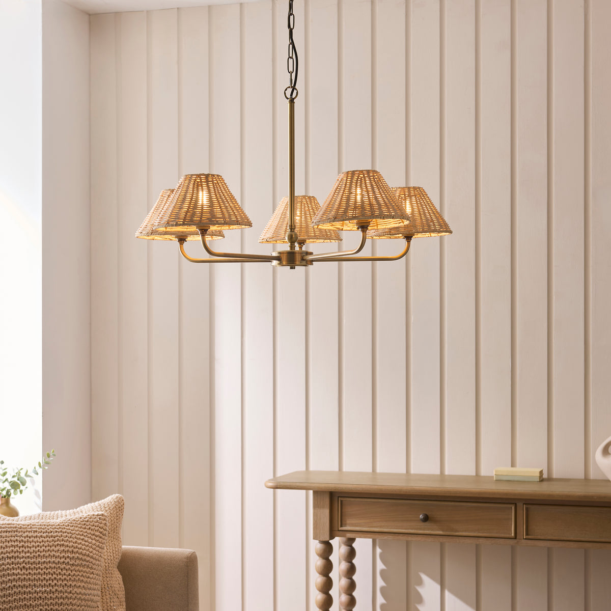 Jericho brass five-arm pendant lit above an oak console table in a panelled room