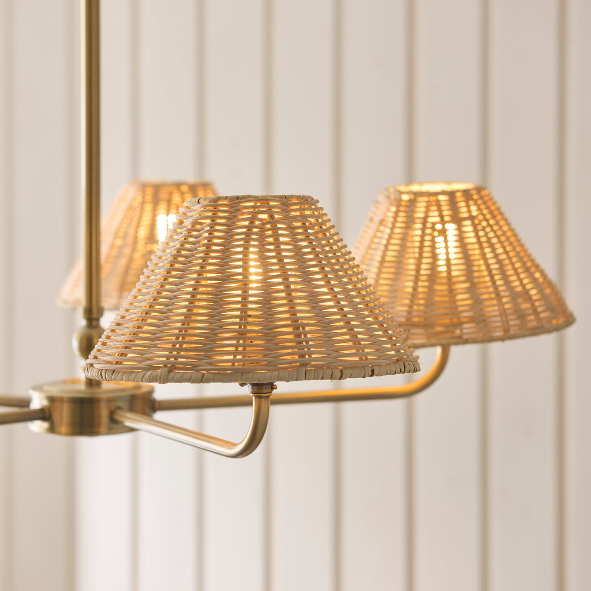 Close view of glowing rattan shades on the Jericho antique brass pendant