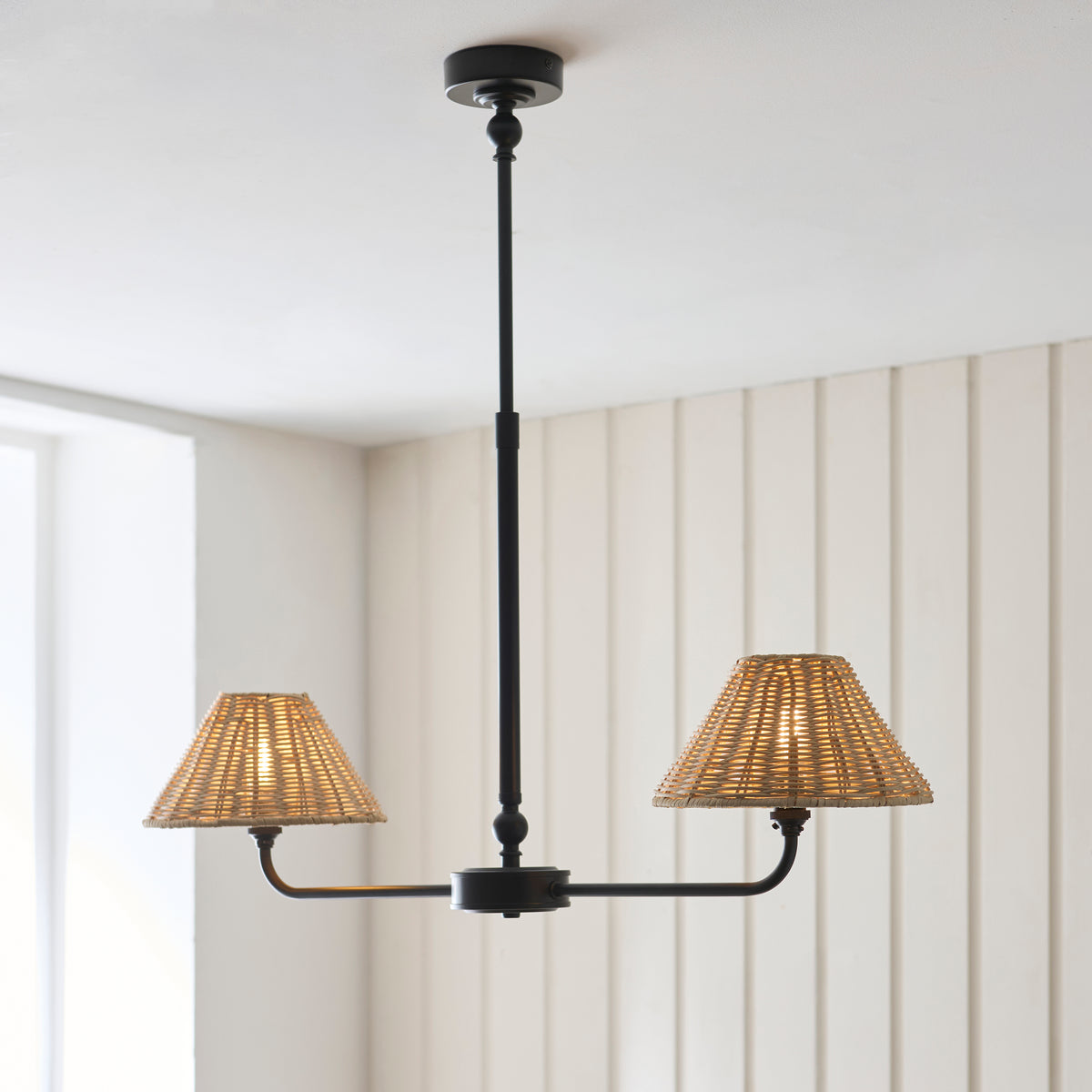 Jericho black two-light linear pendant glowing below a white ceiling and panelled wall
