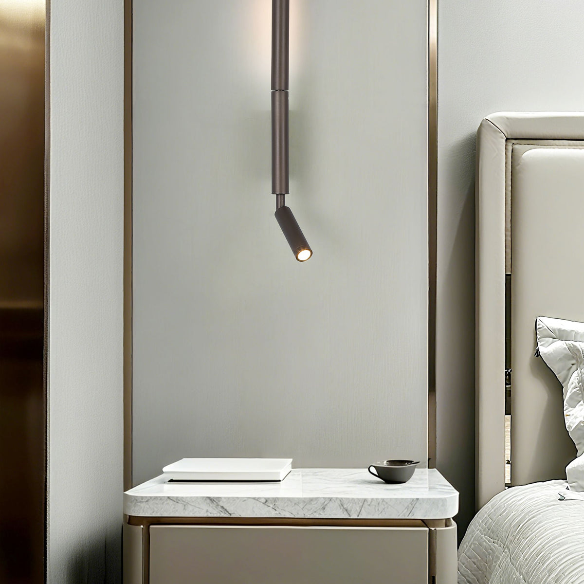 Architect reading wall light beside a marble bedside table and upholstered bed in a bedroom