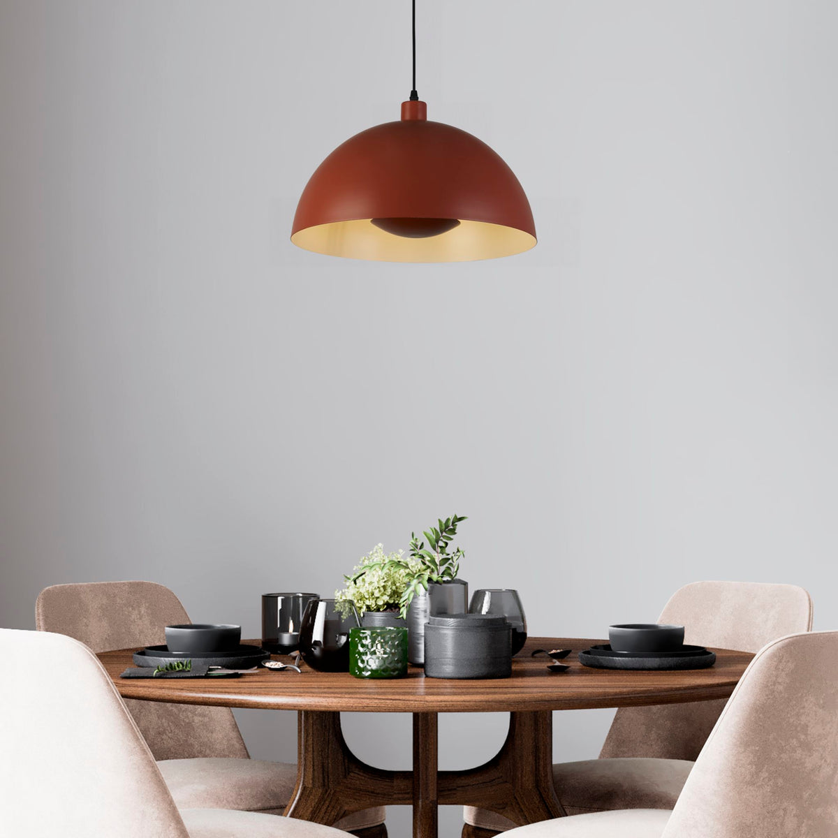 Mars burnt orange pendant above a round walnut dining table set with dark stoneware