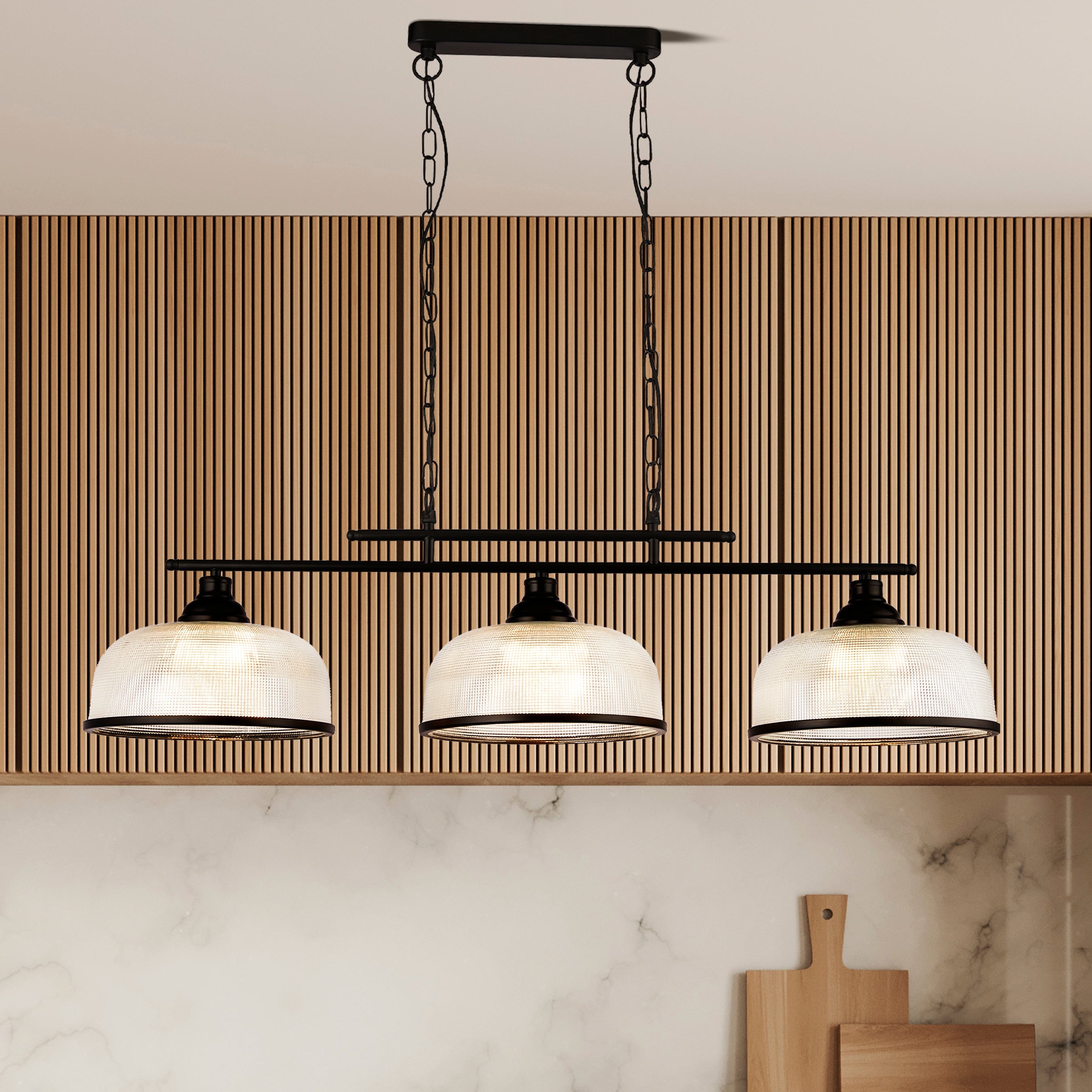 Modern pendant light fixture hanging above a kitchen counter with marble backsplash.