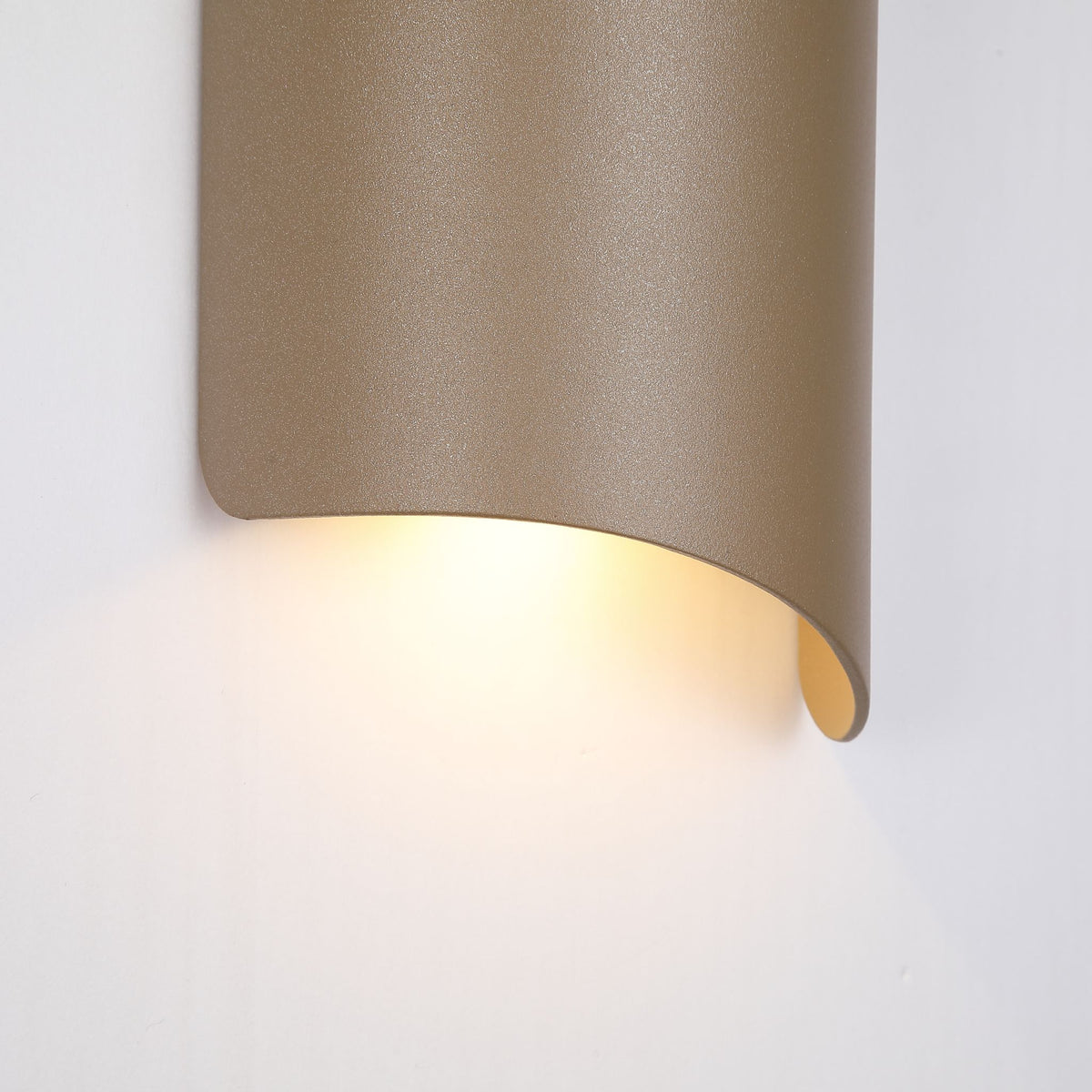 Detail of the Shard gold curved plate with warm light spilling from its open lower edge
