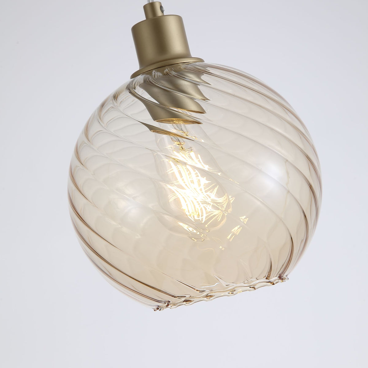Close-up of Radiance swirled champagne glass globe on its brushed gold fitting
