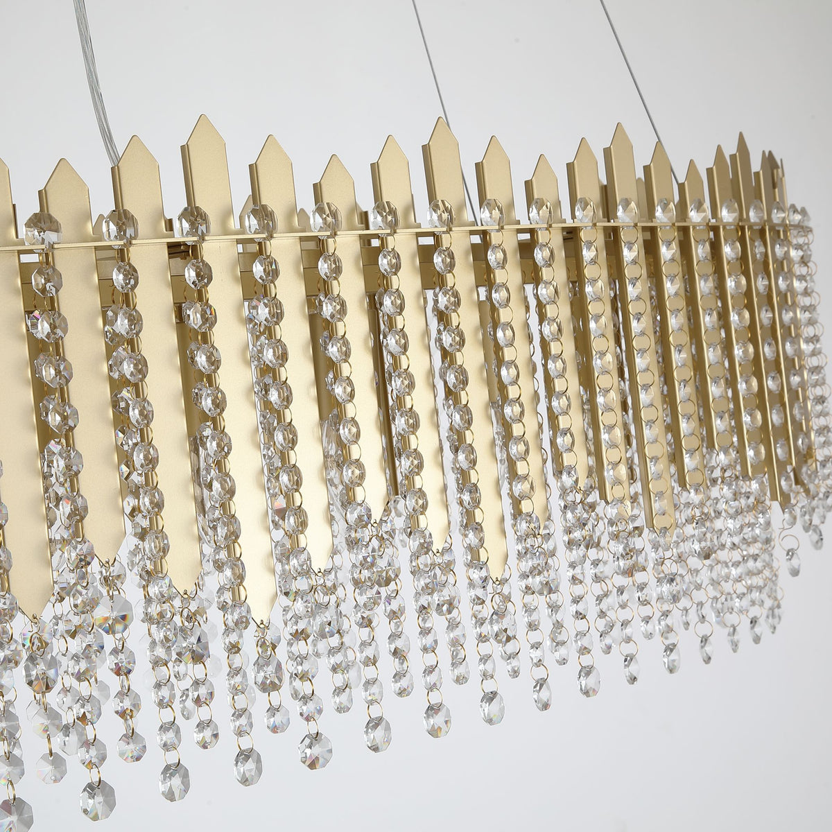 Close-up of Spear bar pendant's pointed gold blades and falling clear crystal bead rows