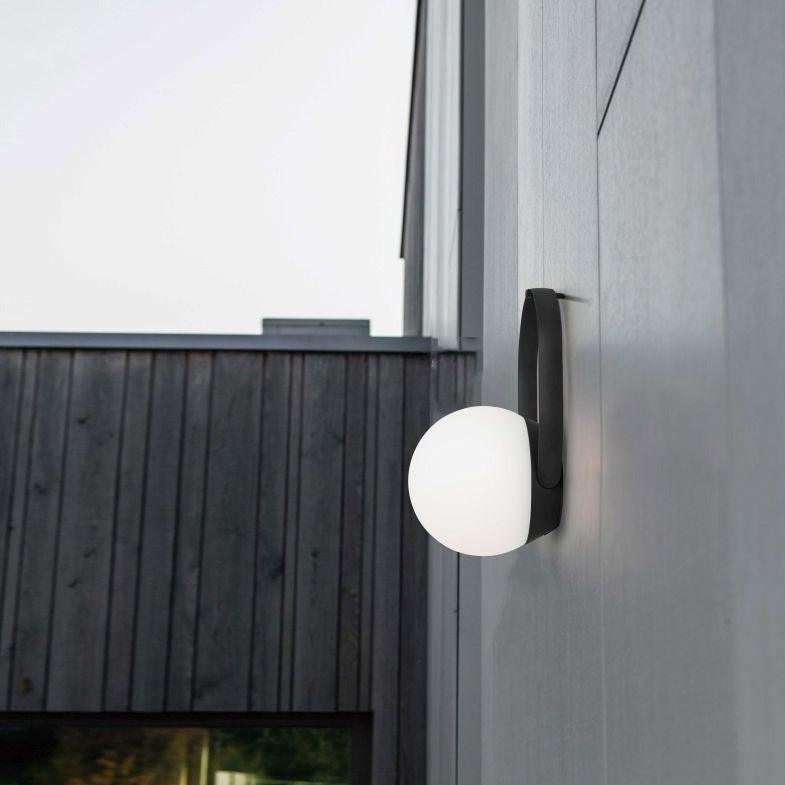 Lutec Cardi Portable Indoor and Outdoor Lamp In Black 6501702330 hanging from an outside wall