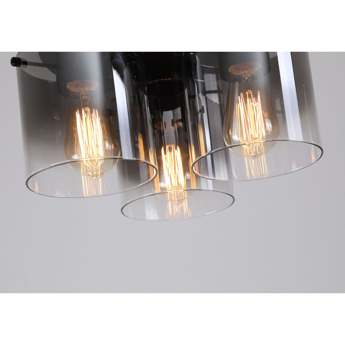 Close-up of the Sweden flush light showing smoked glass cylinders and glowing vintage filament bulbs