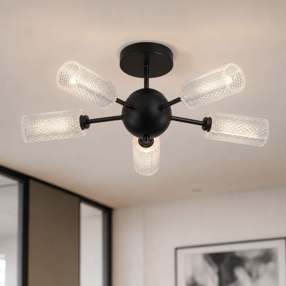 Cosmic black 5-light ceiling light in a pale room with framed print and mirrored wall