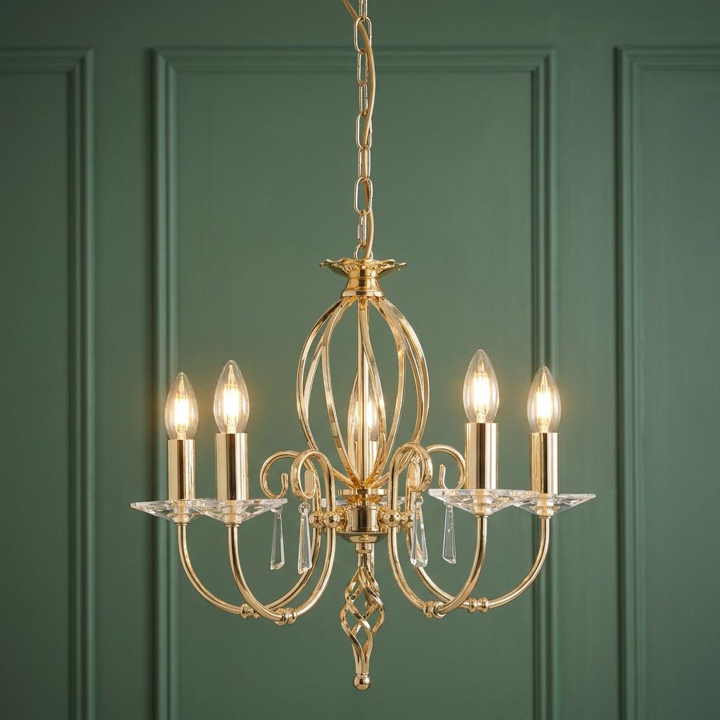 Aegean 5-light polished brass chandelier with crystal glass accents and candle bulbs against a green paneled wall.