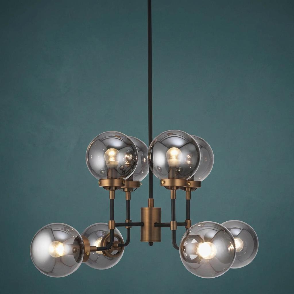Akron Gold and Black Chandelier with smoked glass globe shades against a teal wall.