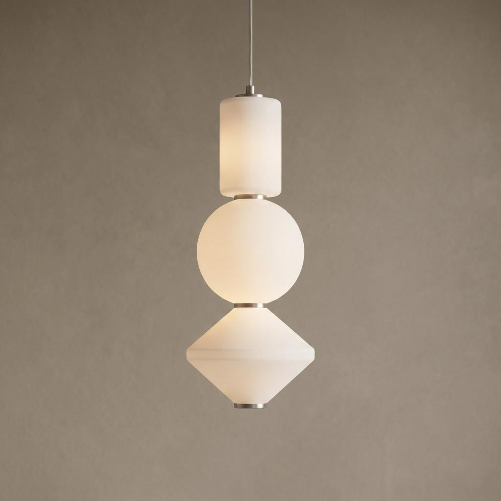 Modern pendant light with stacked cylindrical, spherical, and angular frosted glass shades and brushed nickel accents.