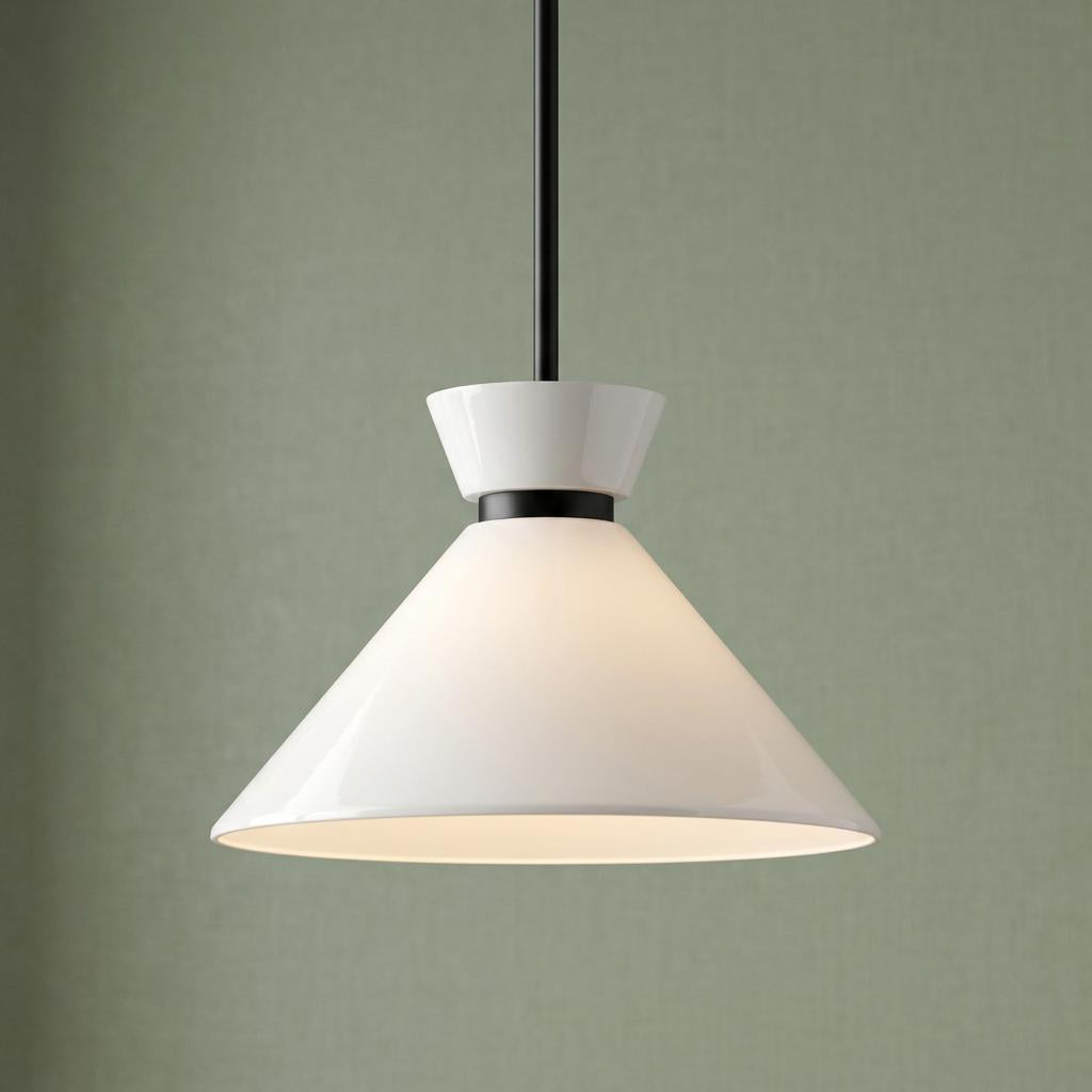Modern white conical pendant light with black accents illuminated against a sage green textured wall.