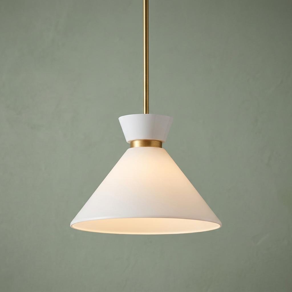 Modern pendant light with white conical shade and gold accents, glowing against a green textured wall.