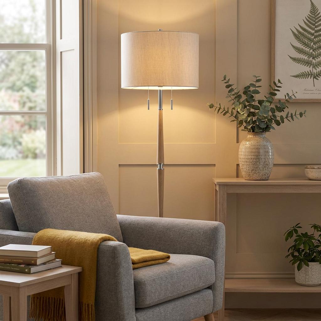Altesse floor lamp with a wooden stand and oatmeal fabric shade in a warm, cozy living room setting.