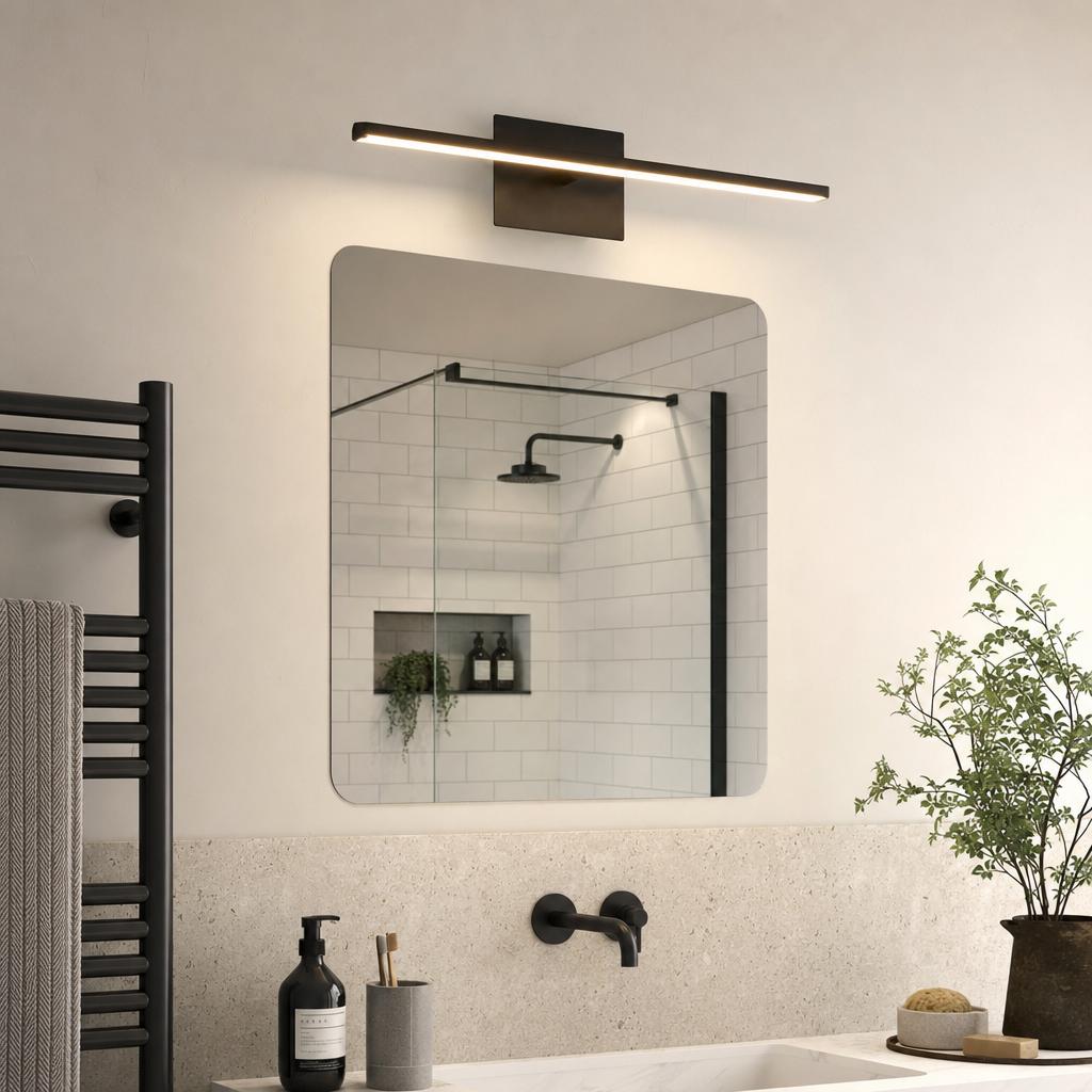 A matt black Amalfi linear wall light illuminates a modern bathroom mirror in a sleek, neutral interior setting.