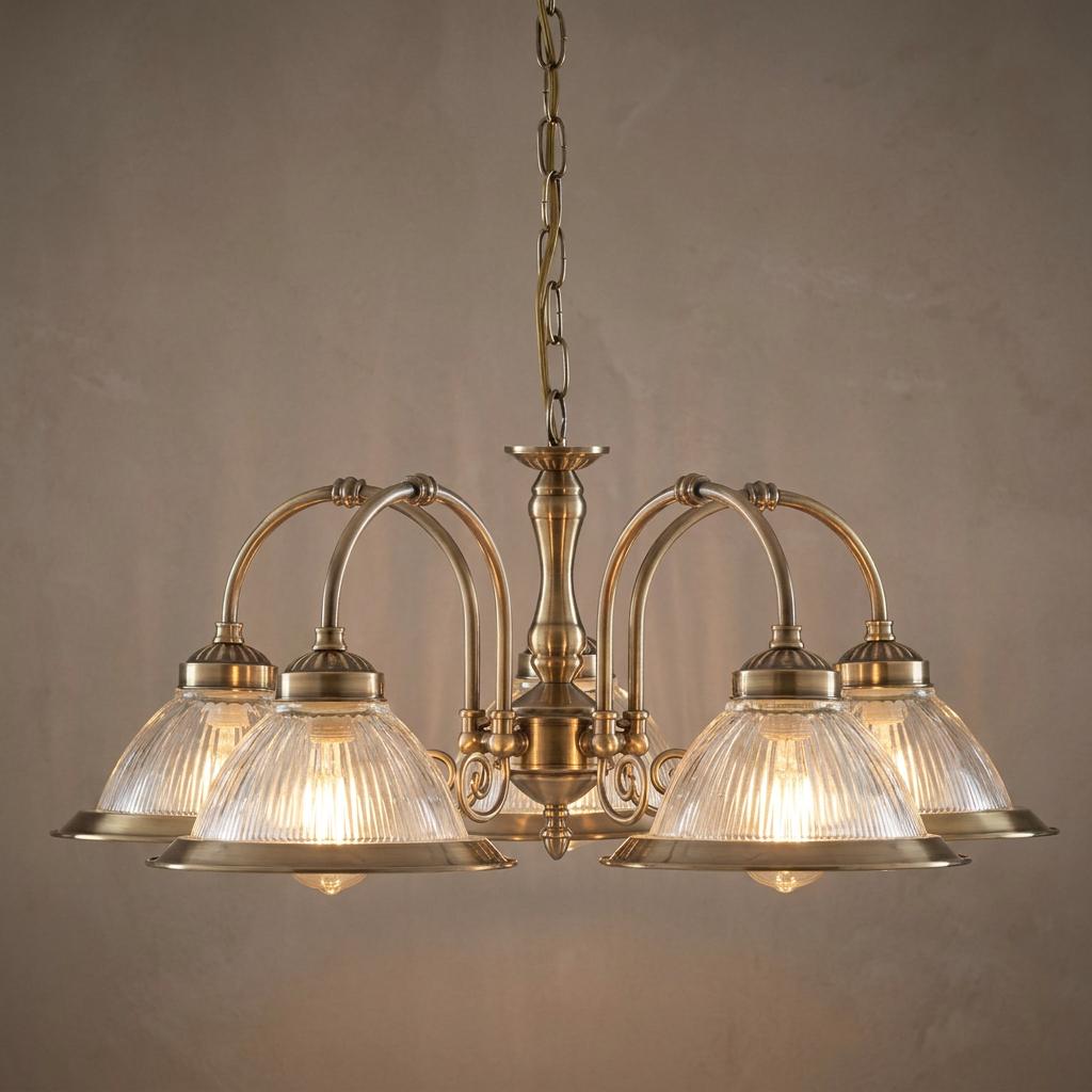 Five-light American diner ceiling pendant in antique brass with ribbed glass shades hanging from a metal chain.