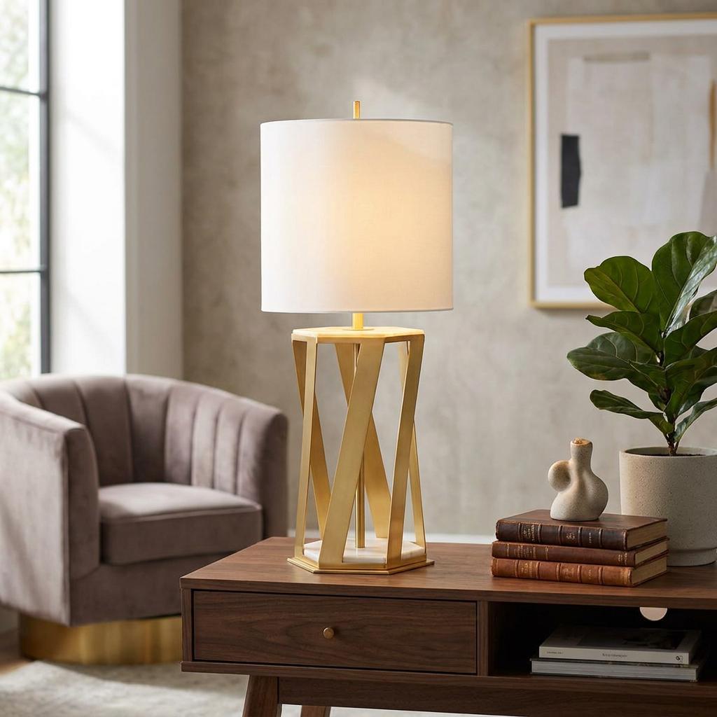 Apollo 1 Light Brushed Brass Table Lamp with a sculptural geometric base and white drum shade in a living room.