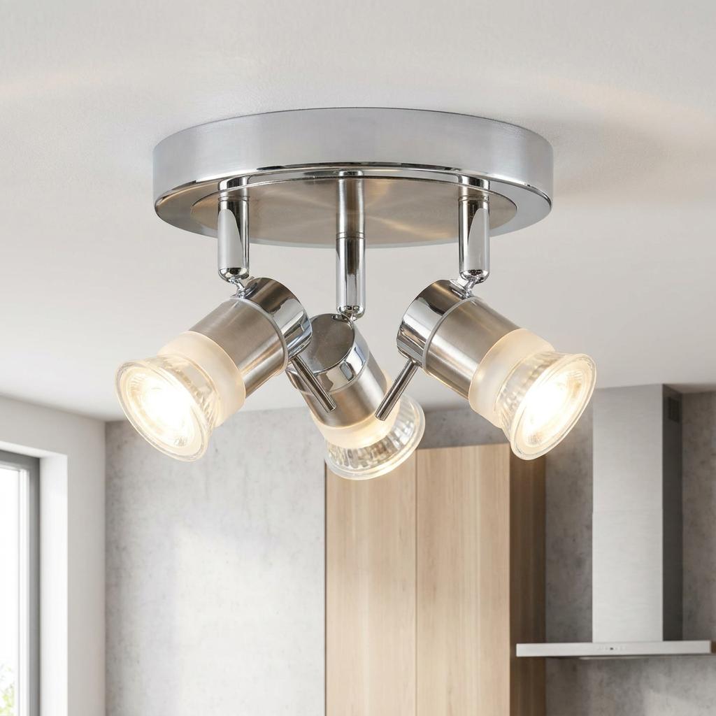 Aries Chrome 3 light adjustable round flush spotlights on a kitchen ceiling, emitting warm light.